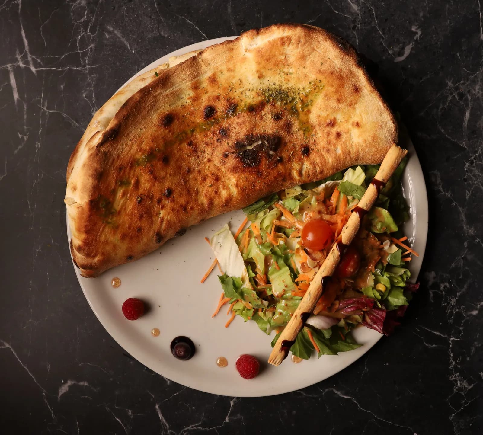 Goldene Calzone mit frischem Salat, Kirschtomaten und Grissino